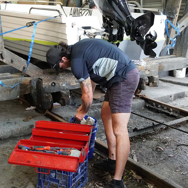 Team member servicing an outboard engine. Team member servicing an outboard engine.